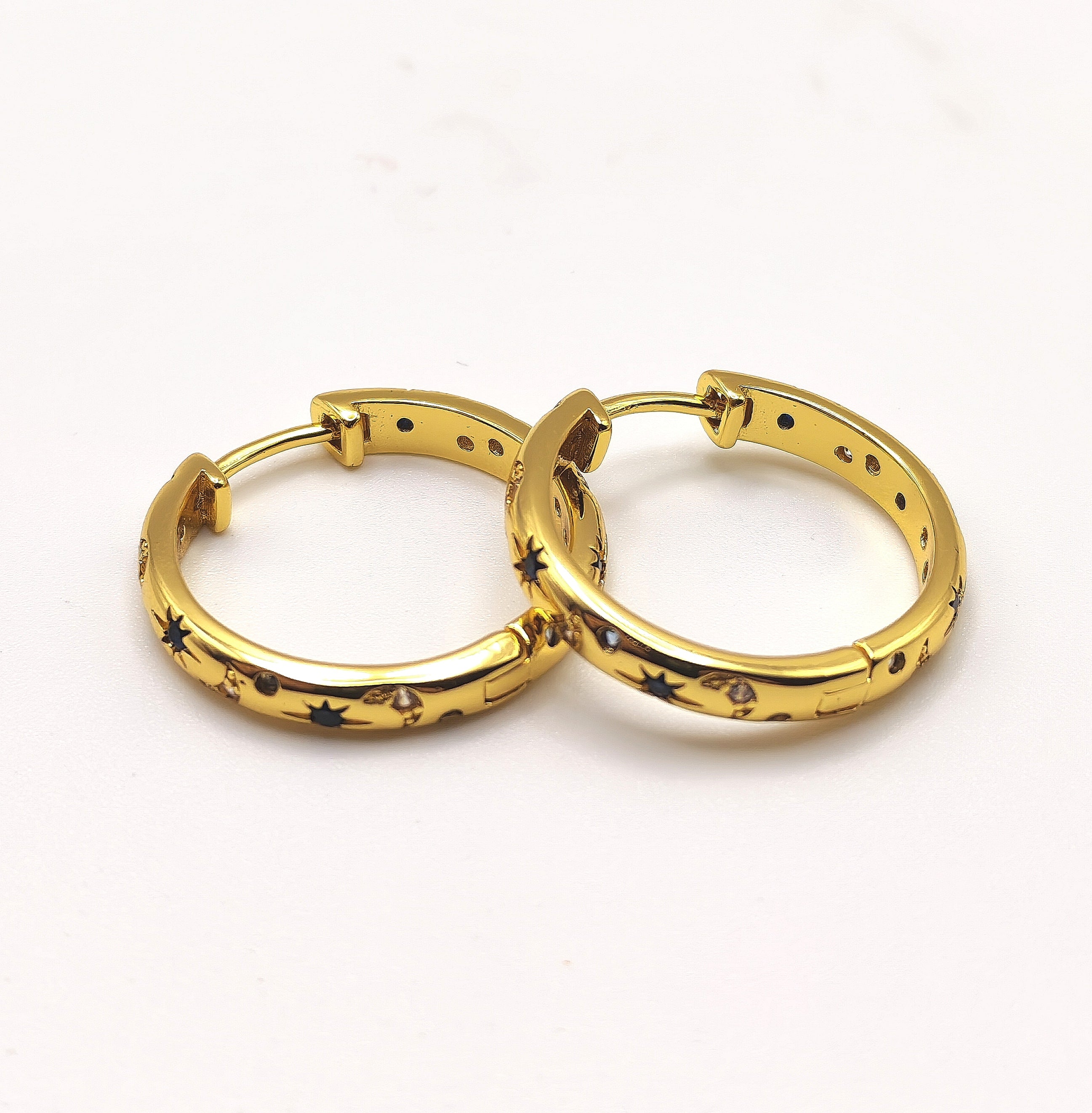 18ct gold plated sterling silver hoop earrings with blue and white zirconia's displayed on a white background.