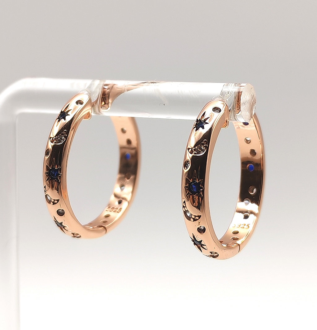 Side angle of rose gold hoop earrings highlighting engraved star motifs and sparkling zirconia's.
