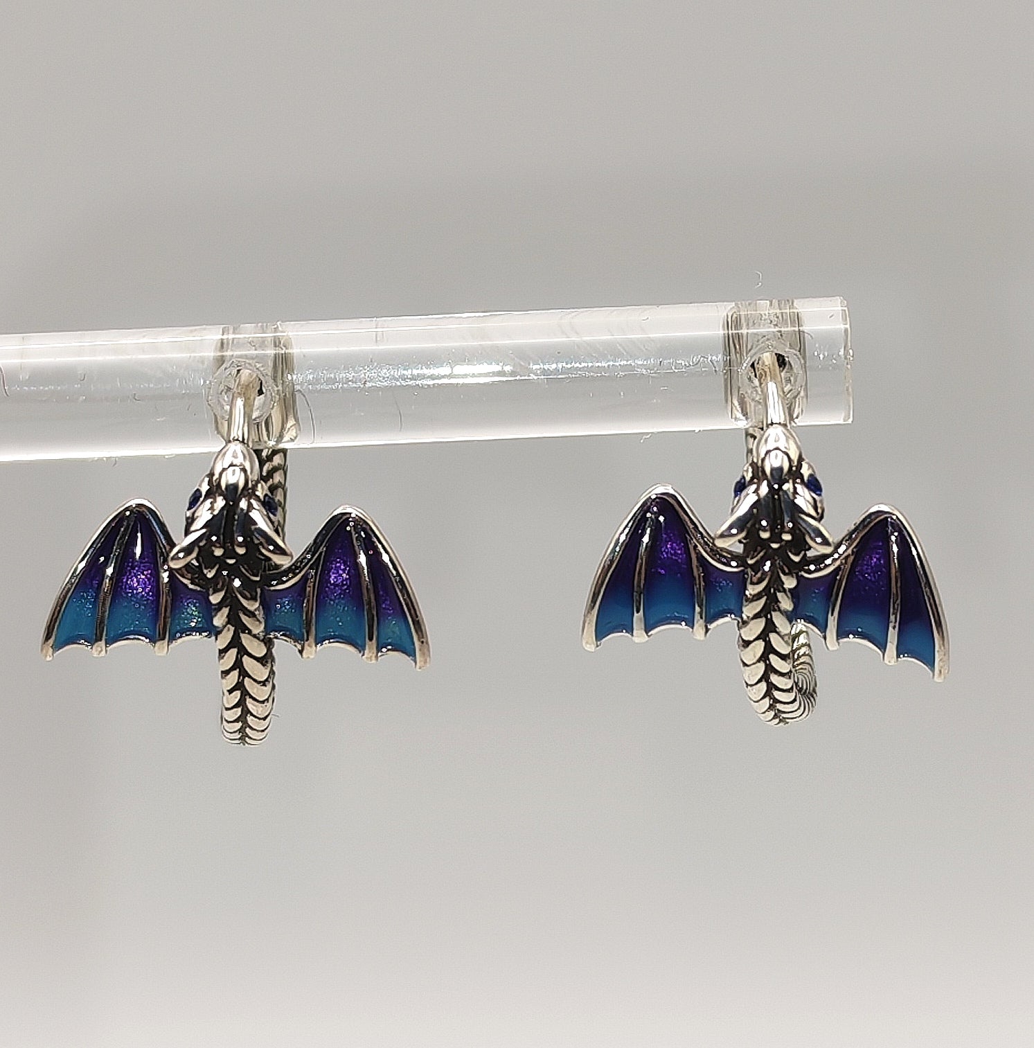 Detailed view of dragon head and wing on sterling silver hoop earring