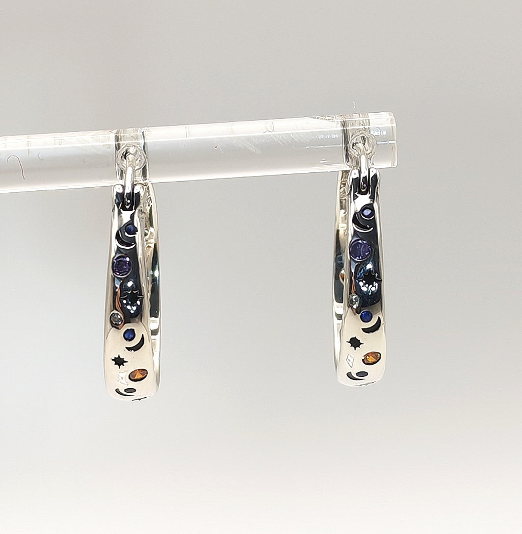 Sterling silver celestial hoop earrings photographed on a white background.