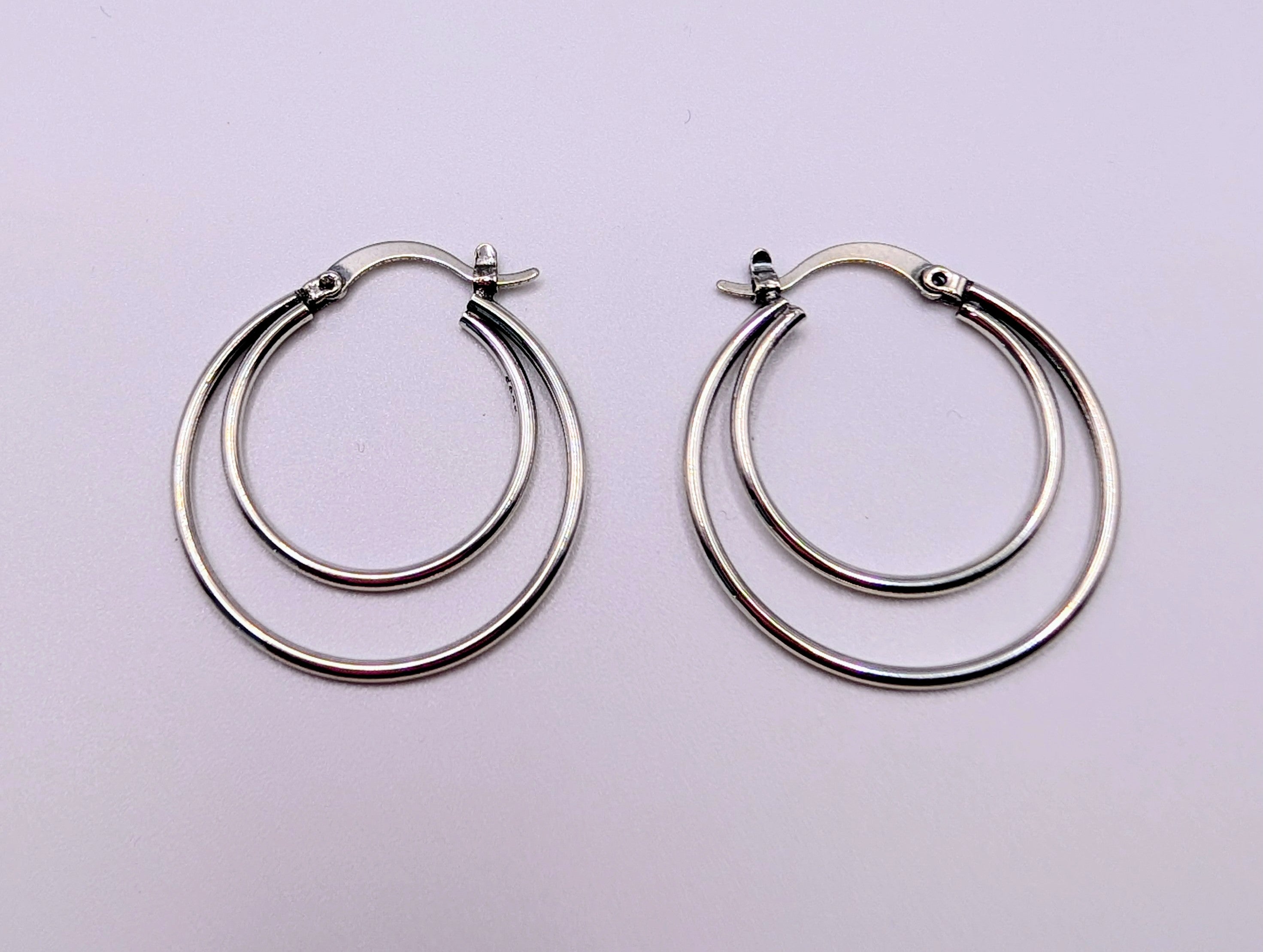 Back view of sterling silver double hoop earrings showing the stud-and-latch fastening.