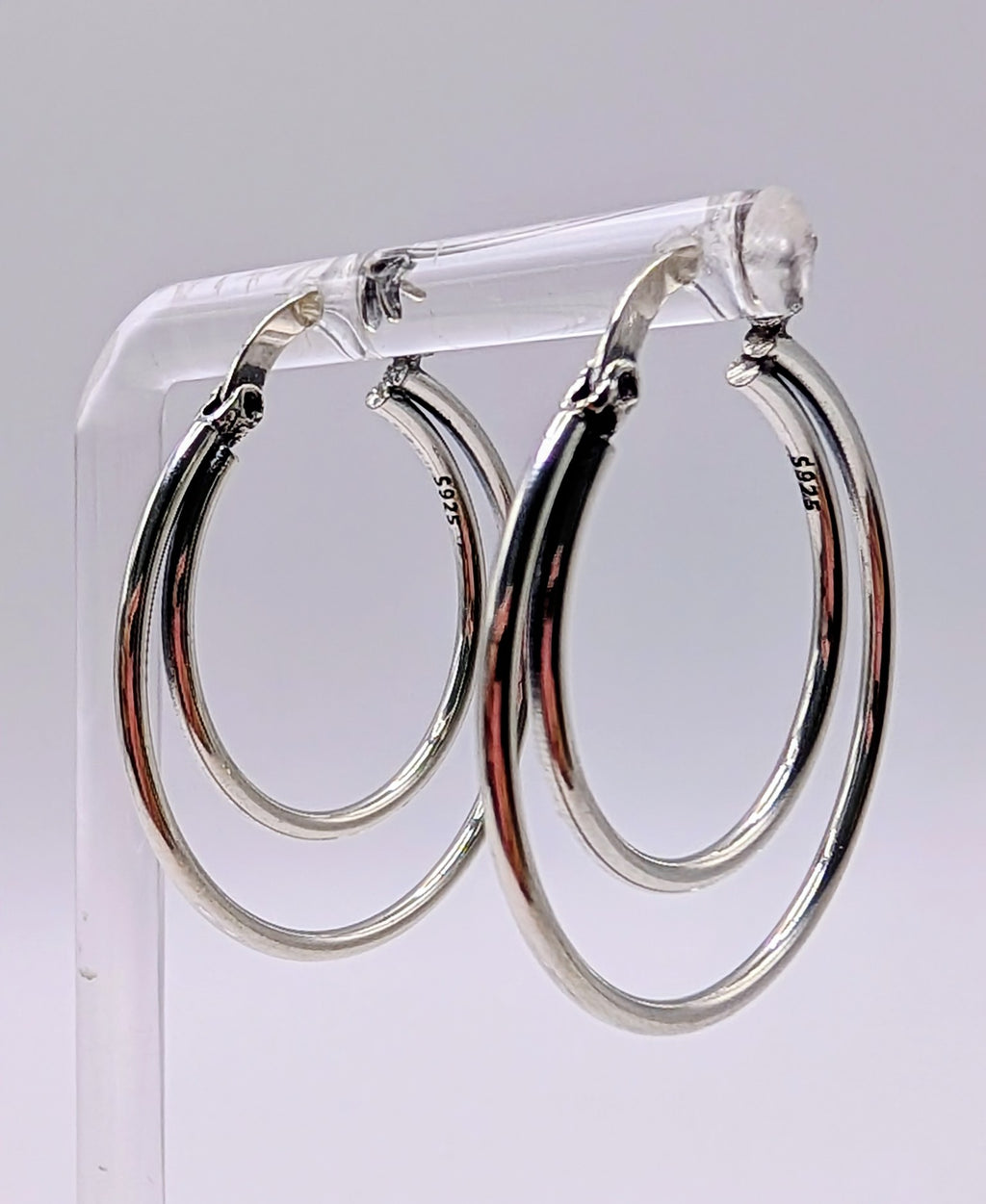 Side angle of layered silver hoop earrings highlighting the double-hoop design.