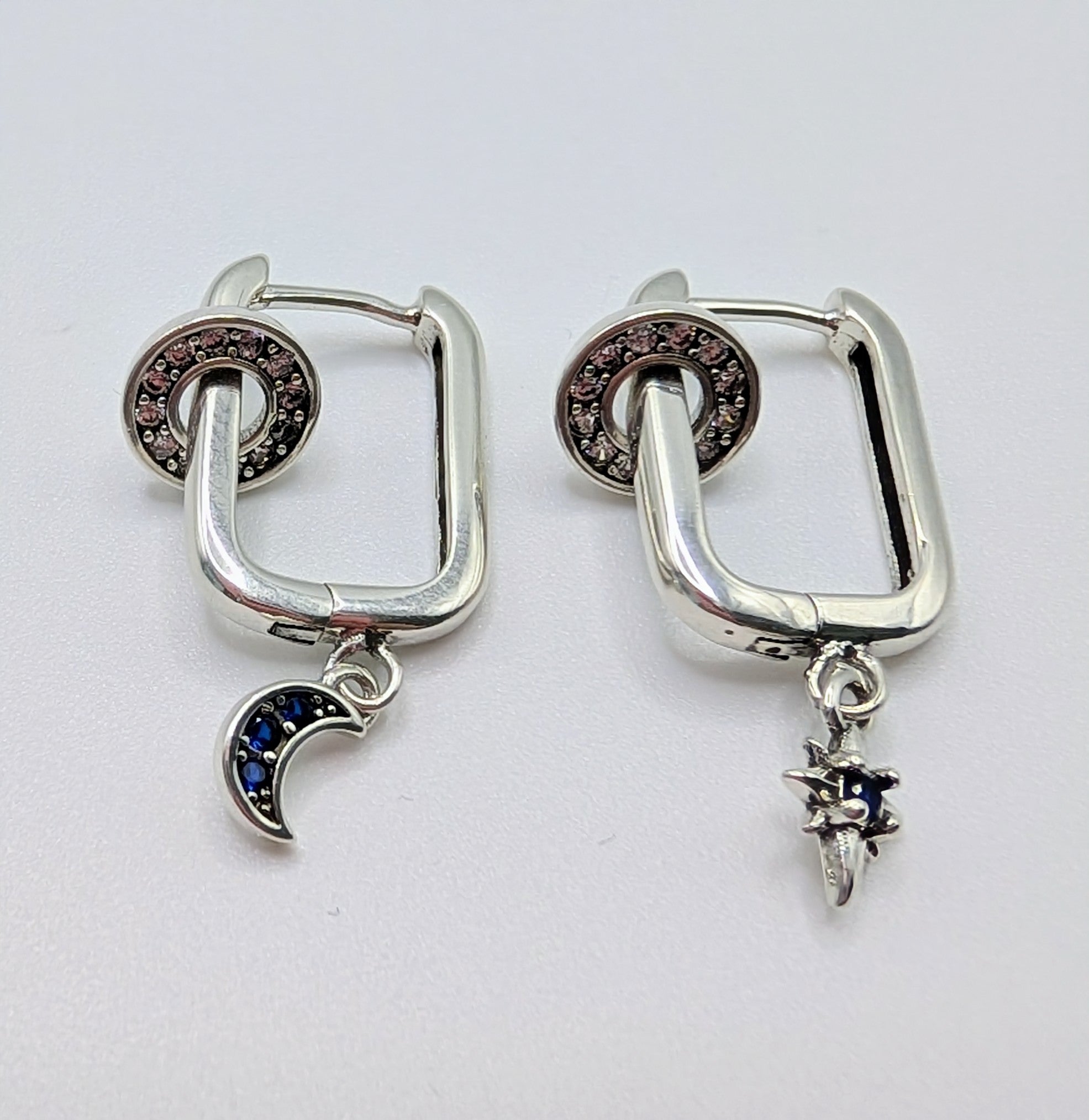 Sterling silver mismatched sun and moon hoop earrings with blue stones