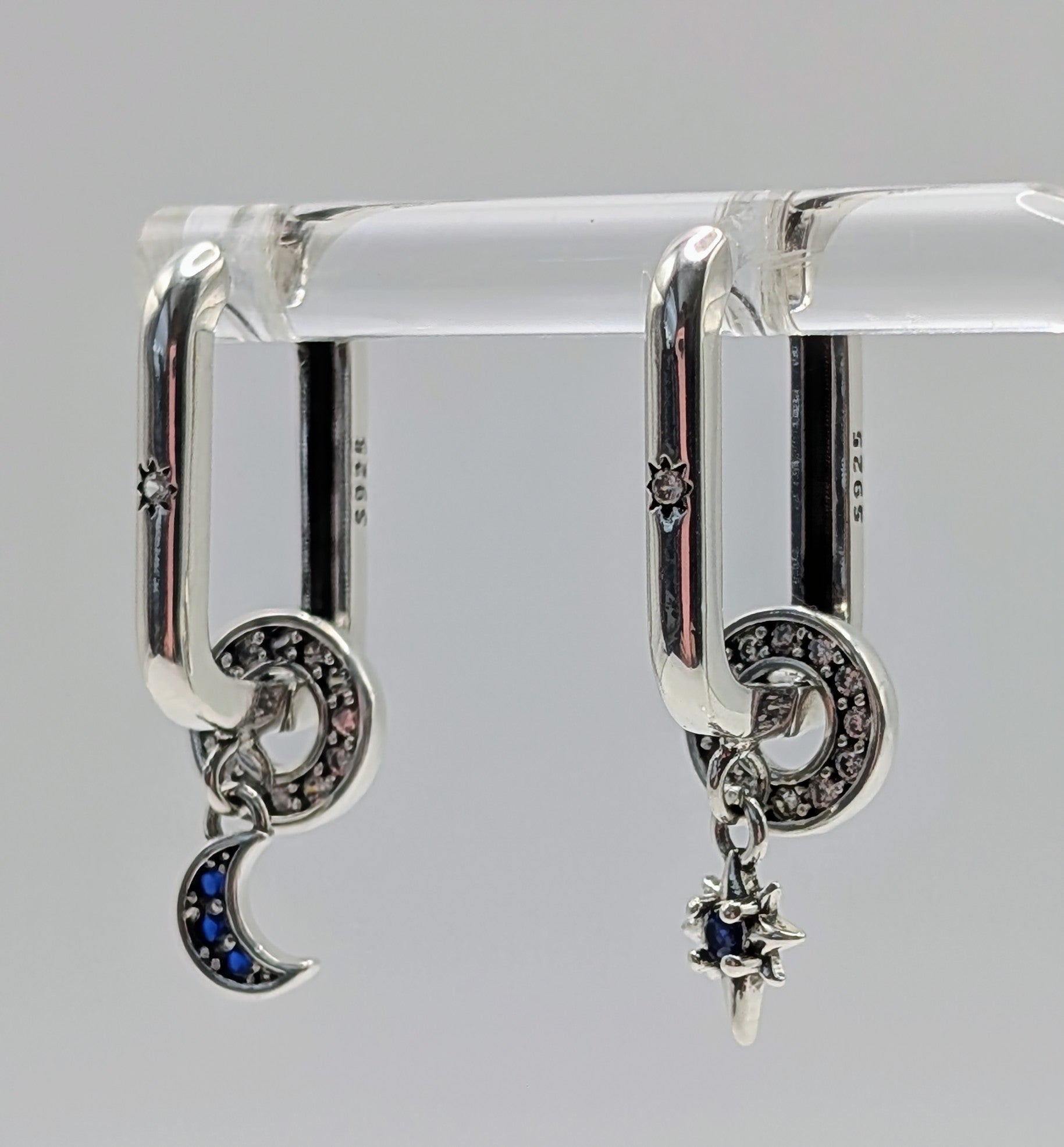 Sterling silver mismatched sun and moon hoop earrings with blue stones