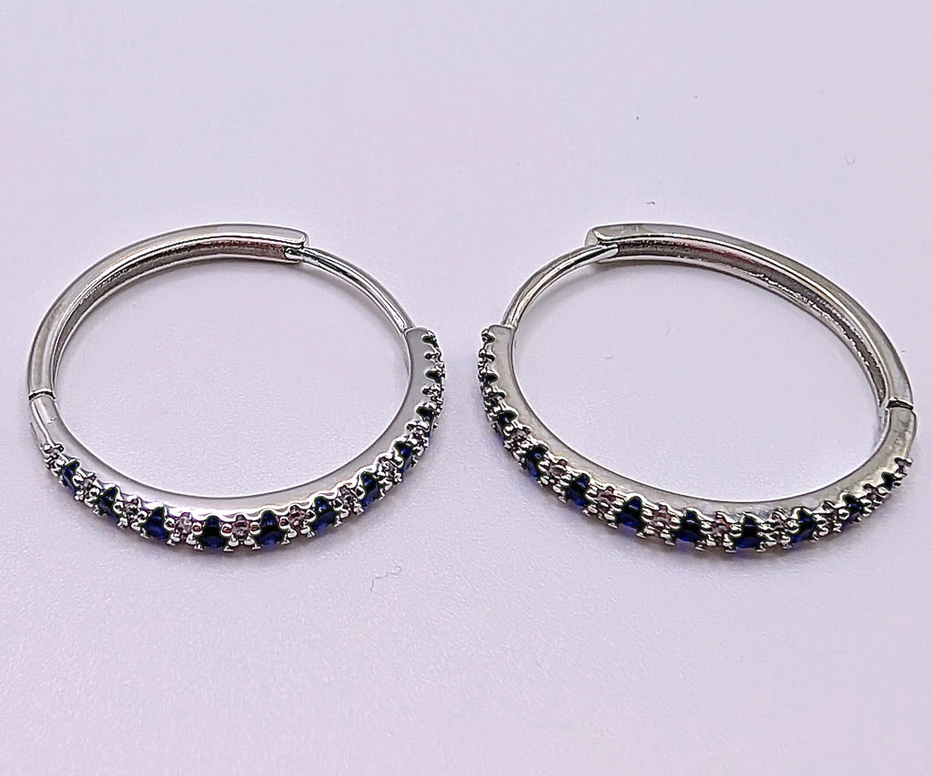 Elegant sterling silver hoops with sparkling blue and clear zirconia stones