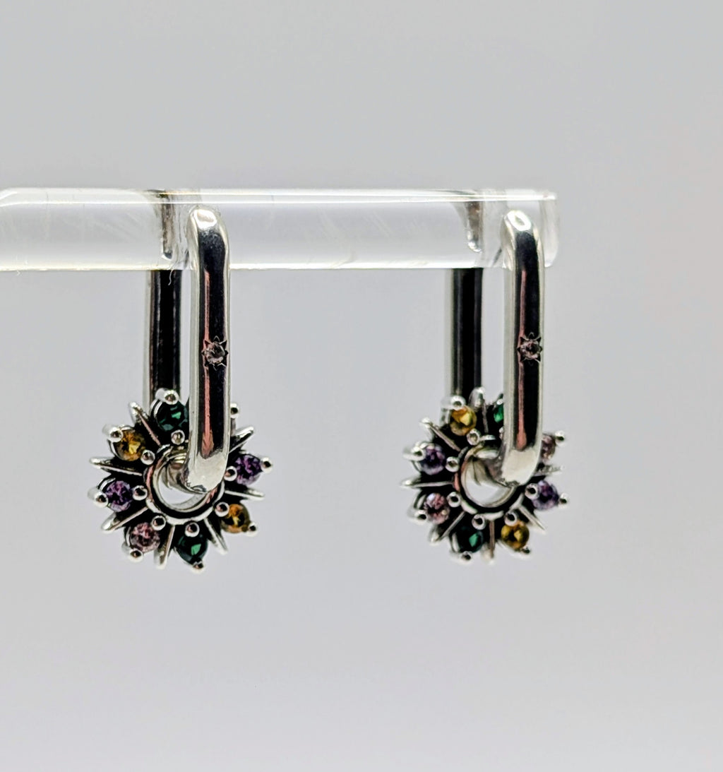 Close-up showing the detail of the Sterling Silver oblong hoop and the vibrant, sparkly multi-color CZ gems on the starburst charm.