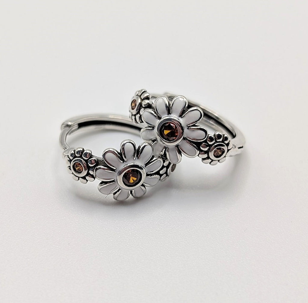 Close-up of daisy floral detailing on sterling silver hoop earrings