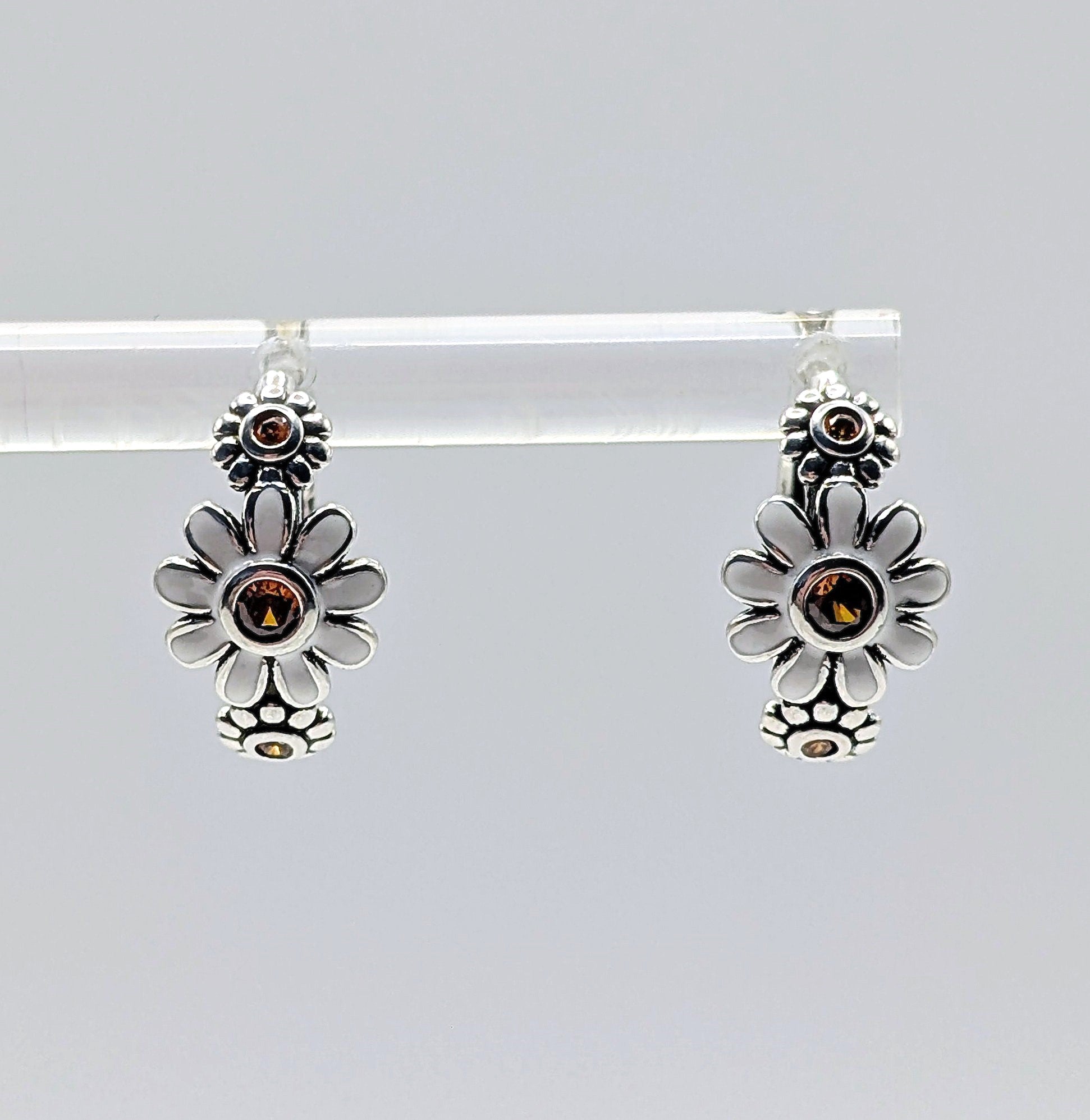 Floral sterling silver hoop earrings with amber stones on white background