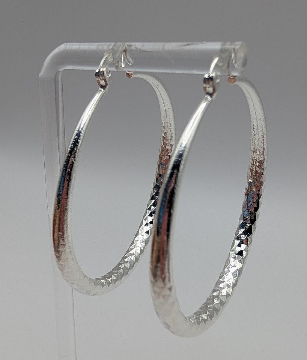 Classic sterling silver textured hoop earrings on display stand